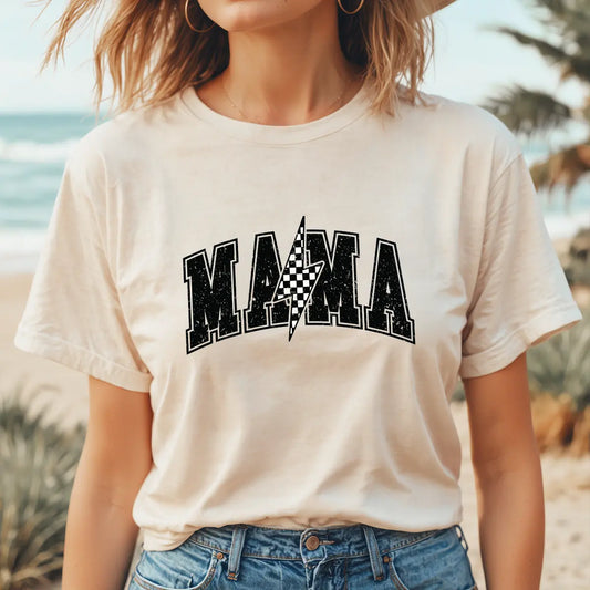 Woman in tan tee wearing bold varsity-style “MAMA” with checkered lightning bolt graphic – featuring DTF Transfers ready to press for custom t-shirt designs.