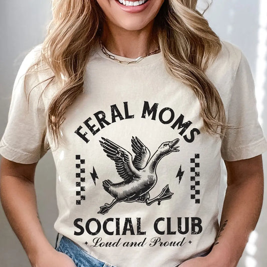 DTF Transfers ready to press featuring “Feral Moms Social Club – Loud and Proud” with a flying goose and grunge-style text on a cream t-shirt.