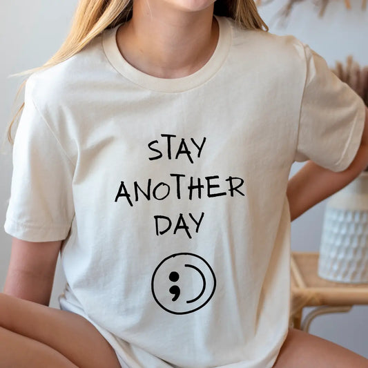 DTF Transfers ready to press – black handwritten “Stay Another Day” with semicolon symbol on neutral t-shirt, minimalist mental health awareness design.