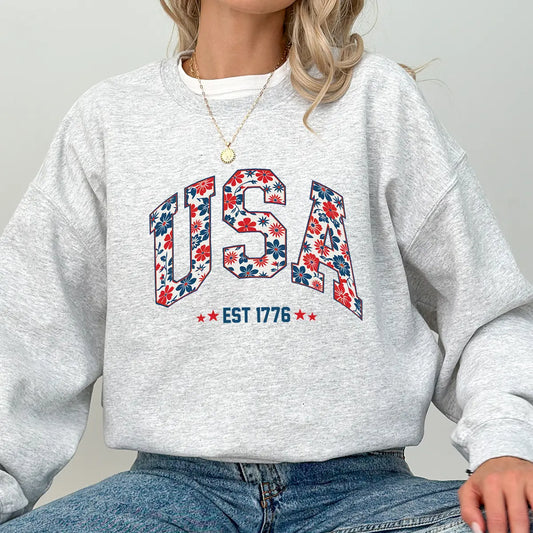 Gray sweatshirt with floral USA EST 1776 DTF transfer design in red, white, and blue colors, perfect for patriotic and feminine-themed apparel.