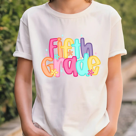 White T-shirt with colorful “Fifth Grade” DTF transfer design in big, bright bubble letters and flower accents.