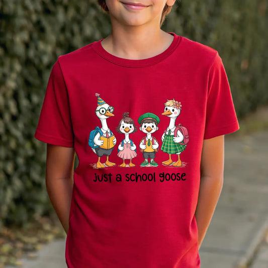 Red T-shirt with “just a school goose” DTF transfer design featuring four cute cartoon geese dressed in colorful school clothes with backpacks.
