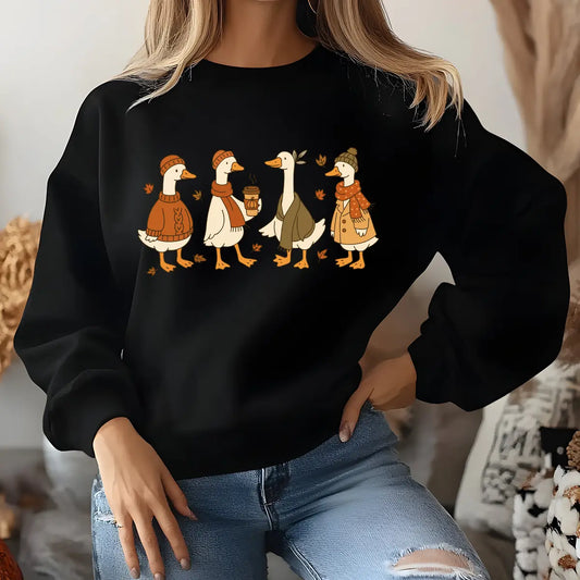 Black sweatshirt with fall-themed DTF transfer design of four ducks in cozy autumn clothing, accented with falling leaves.