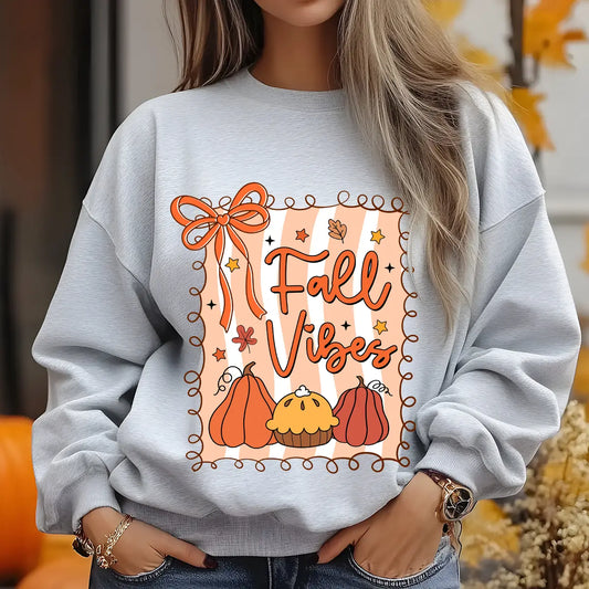 Gray sweatshirt with “Fall Vibes” DTF transfer design featuring pumpkins, autumn pie, orange bow, and falling leaves in a decorative border.