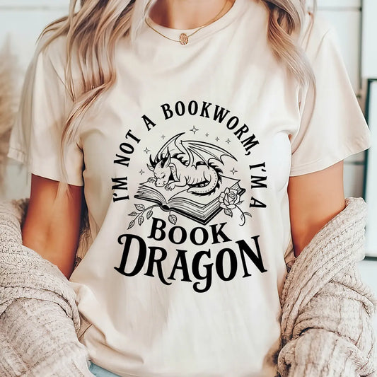 Natural t-shirt with black “I’m Not a Bookworm, I’m a Book Dragon” DTF transfer design featuring a dragon on a book with floral accents.