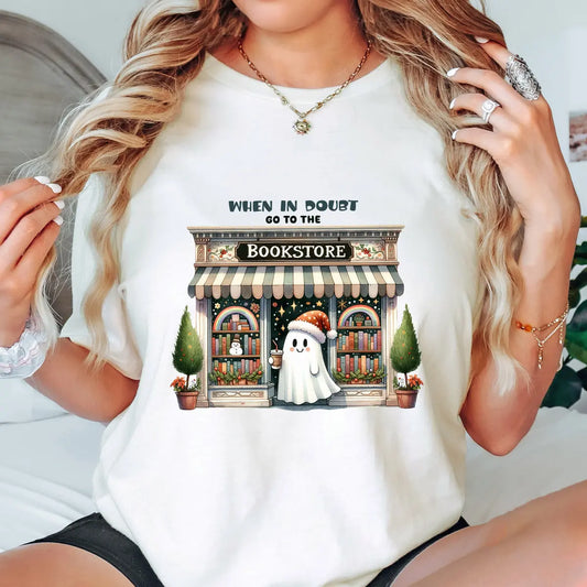 Natural t-shirt with “When in Doubt Go to the Bookstore” DTF transfer featuring a cute ghost in front of a cozy bookstore for spooky reader style.