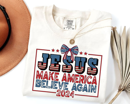 "Jesus Make America Believe Again" 4th of July DTF Transfer featuring patriotic stars and stripes text with a red, white, and blue bow.