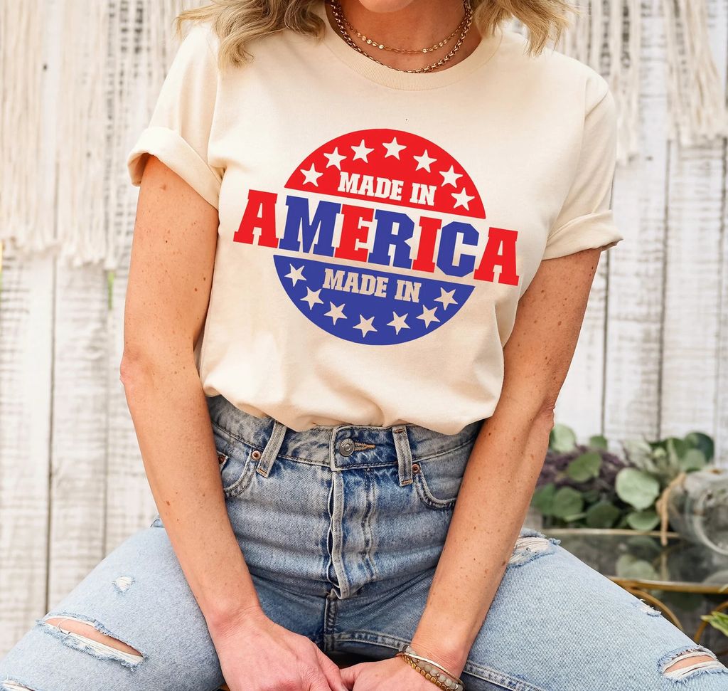 Beige t-shirt featuring a Made in America patriotic design in red, white, and blue with bold typography and stars, ideal for 4th of July DTF transfers.