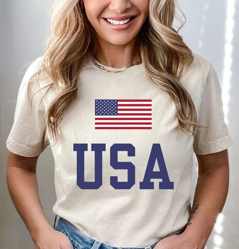 Classic USA flag and bold varsity USA lettering on a cream-colored t-shirt, perfect for 4th of July Ready-to-Press DTF Transfers.