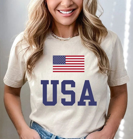 Classic USA flag and bold varsity USA lettering on a cream-colored t-shirt, perfect for 4th of July Ready-to-Press DTF Transfers.