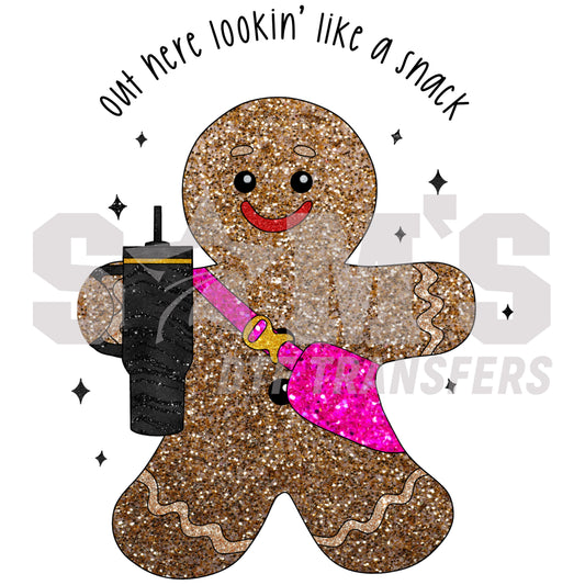 Glittering gingerbread man with sunglasses and drink, captioned 'out here lookin' like a snack', a premium custom DTF design by Sam's DTF Transfers."  Page title for search engine listing