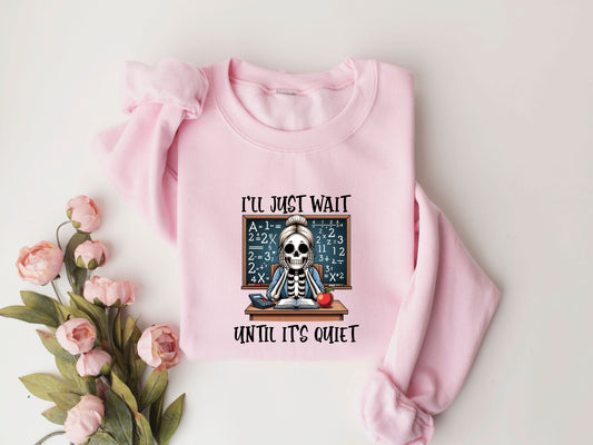 "I'll Just Wait Until It's Quiet" DTF transfer design on a pink sweatshirt featuring a skeleton teacher at a desk with math equations on a chalkboard, perfect for humorous back-to-school apparel.