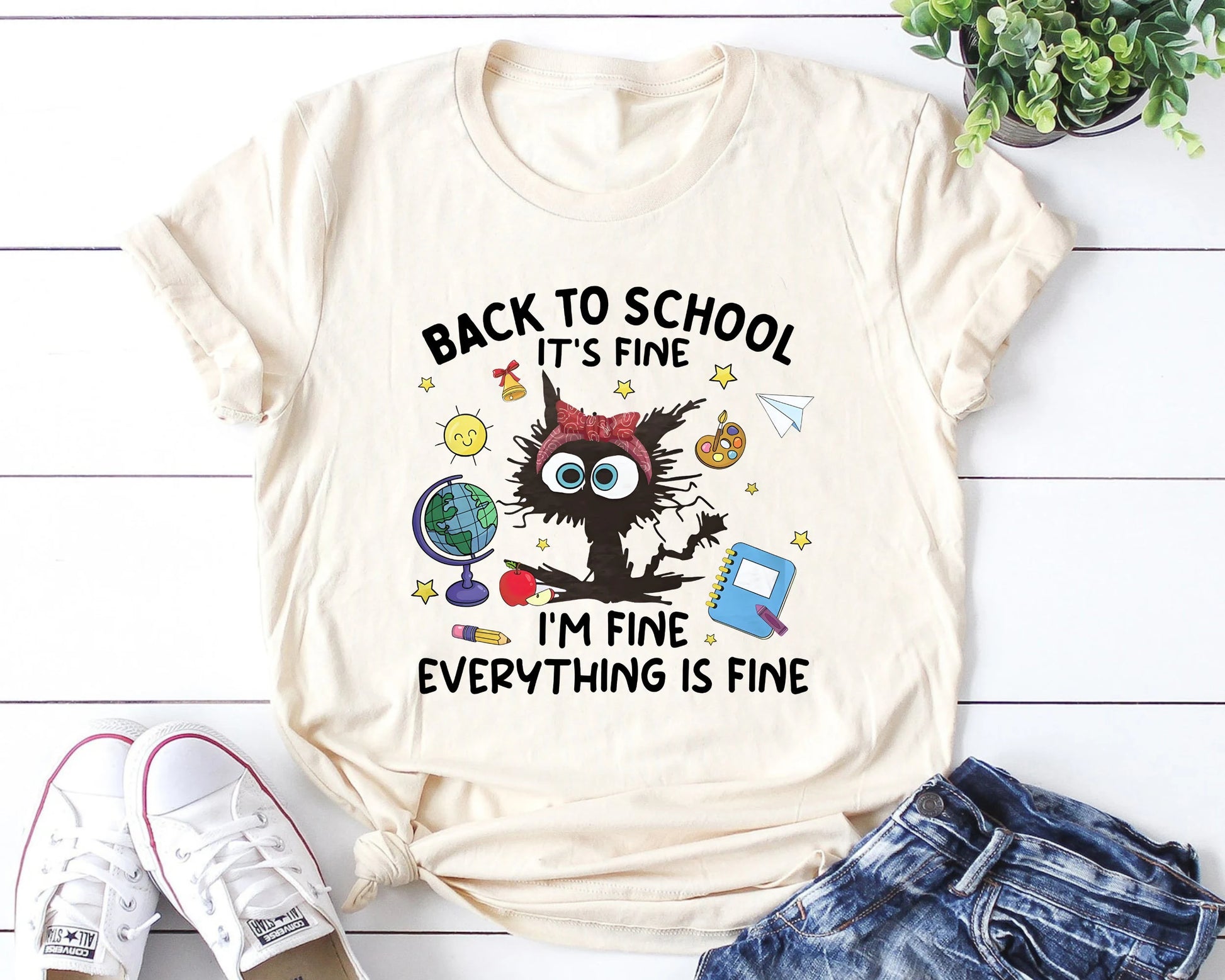 "Back to School It’s Fine, I’m Fine, Everything Is Fine" DTF transfer design on a beige t-shirt featuring a frazzled character with wide eyes surrounded by school icons like a globe, apple, and notebook, perfect for humorous back-to-school apparel.