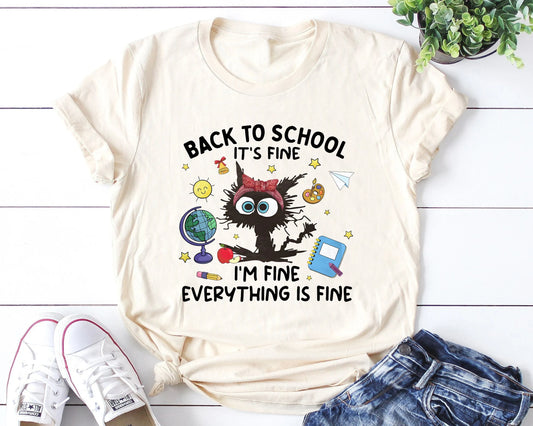 "Back to School It’s Fine, I’m Fine, Everything Is Fine" DTF transfer design on a beige t-shirt featuring a frazzled character with wide eyes surrounded by school icons like a globe, apple, and notebook, perfect for humorous back-to-school apparel.