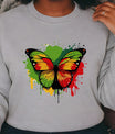 Gray sweatshirt with a colorful butterfly Black History design on a green background