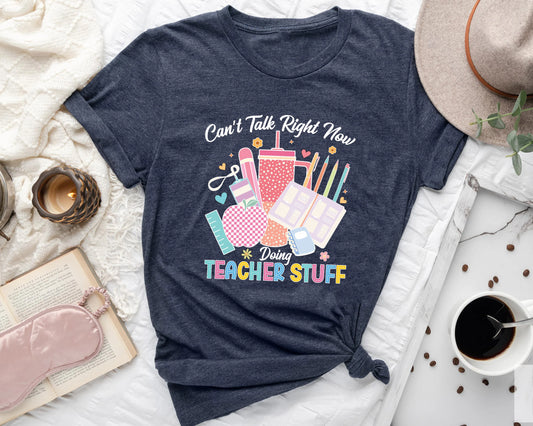 Can’t Talk Right Now Doing Teacher Stuff DTF transfer featuring colorful school supplies, coffee cup, books, and stationery, perfect for teacher t-shirts and hoodies.