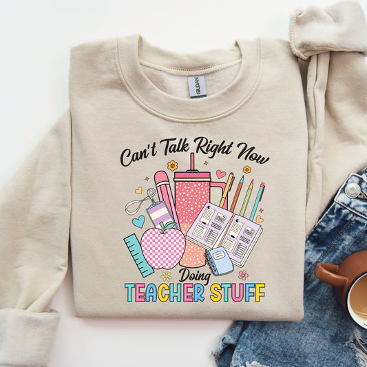 Can't Talk Right Now Doing Teacher Stuff DTF transfer on a beige sweatshirt with school-themed design elements.