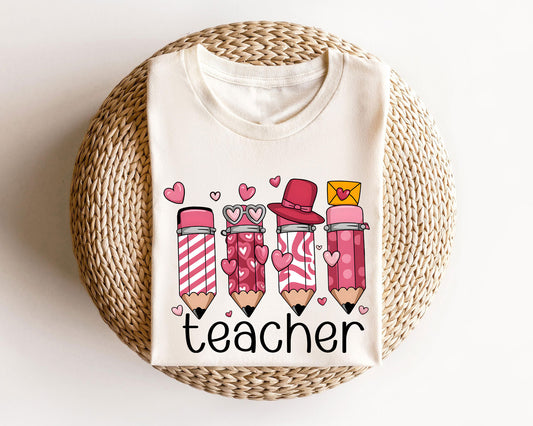 Beige sweatshirt with a Valentine's teacher-themed DTF transfer featuring pink and red pencils decorated with hearts and accessories.