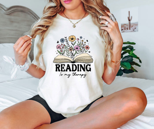 "Reading is My Therapy" DTF transfer design on a white t-shirt with an open book surrounded by blooming flowers.