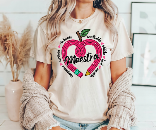 Beige t-shirt with a heart-shaped pencil "Maestra" DTF transfer featuring Spanish teacher appreciation words.