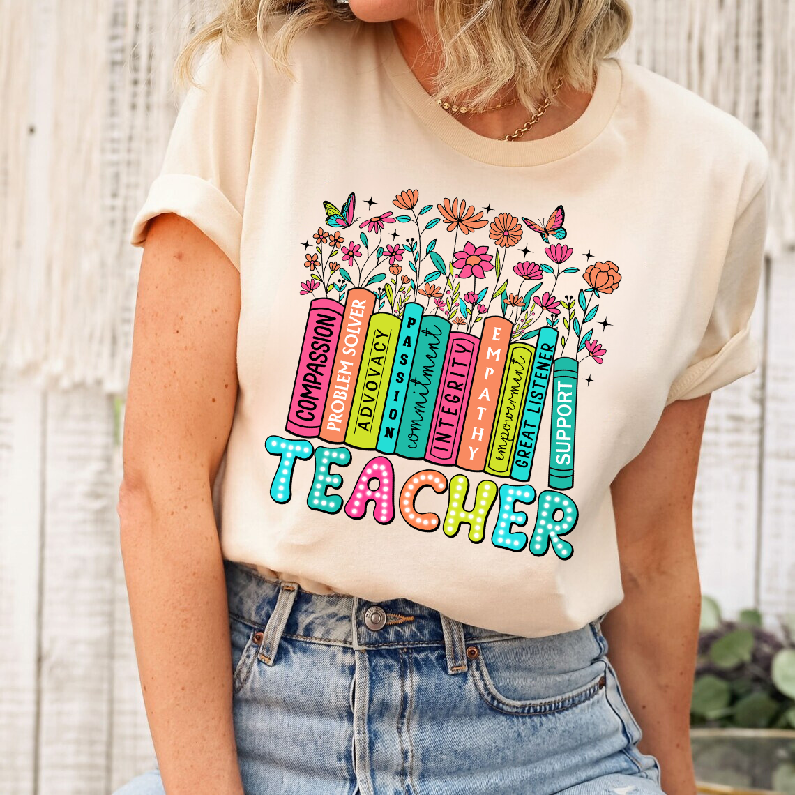 Beige t-shirt with a Teacher Bookshelf floral-themed DTF transfer, showcasing teacher values in a colorful book stack design.