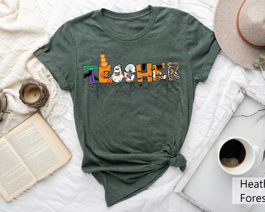 Dark green t-shirt with a Halloween Teacher-Themed DTF transfer, featuring spooky letters, ghosts, pumpkins, and spider webs.