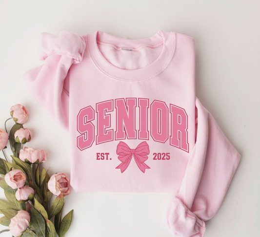 Senior Est. 2025 pink bow DTF transfer on a pink sweatshirt, perfect for graduation t-shirts and hoodies.