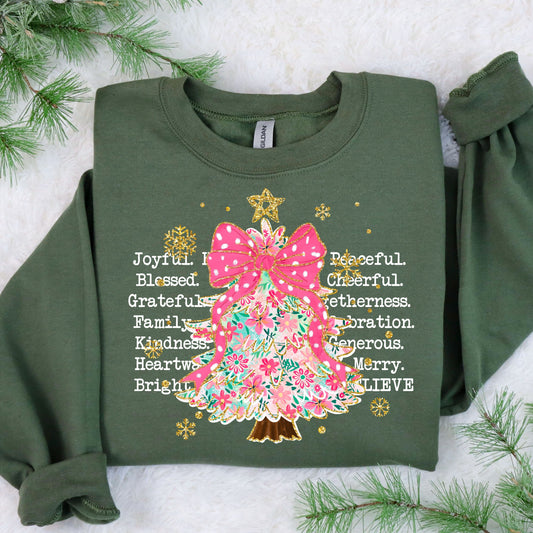 Christmas sweater design featuring a colorful tree with a pink bow, surrounded by words like "Joyful," "Blessed," and "Family."