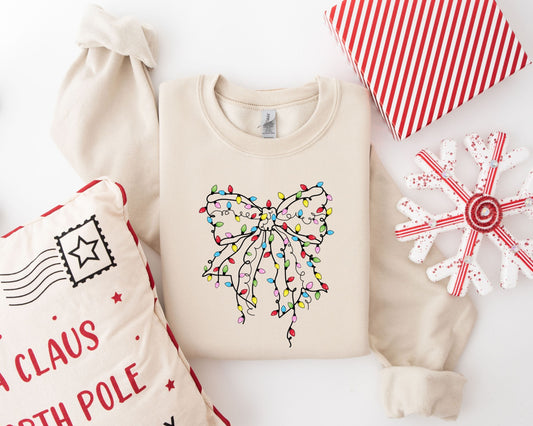 Christmas sweatshirt with a colorful bow made of lights design on a beige background.