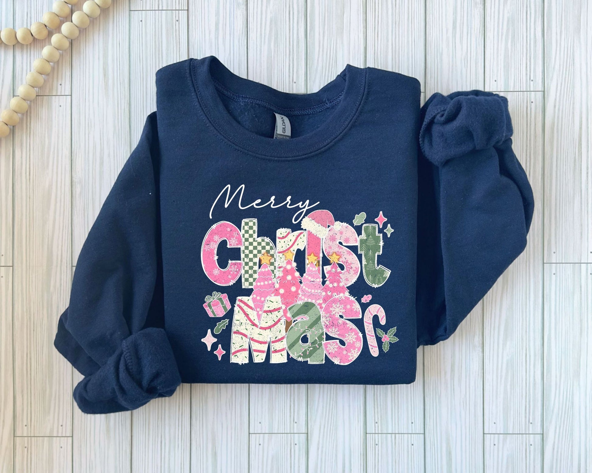 Whimsical Merry Christmas cactus DTF transfer on a navy sweater, featuring colorful cacti and festive decorations.