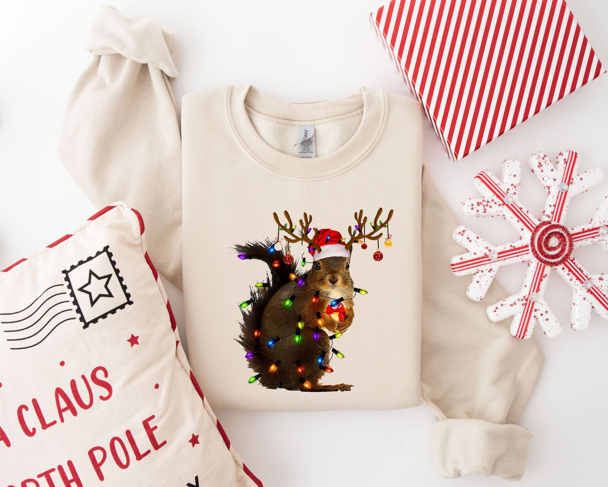 "Festive Squirrel" DTF transfer on a beige sweatshirt, showcasing a squirrel decorated with Christmas lights and reindeer antlers.