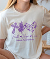 Beige t-shirt featuring a purple Faith Hope Love Lupus Awareness DTF design with a cross, butterfly, and heart made of ribbons.

