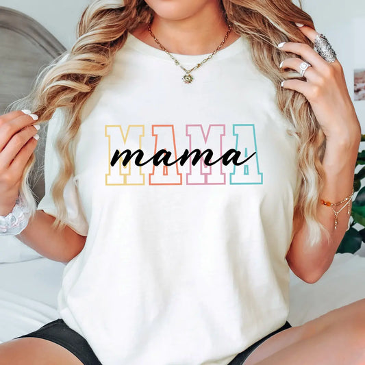 Woman wearing a white tee with pastel block letters spelling “MAMA” and a script overlay, showing off a stylish DTF Transfers ready to press design for moms.