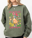 Woman in green sweatshirt featuring Mama Goose DTF Transfers ready to press – a vintage-style goose in floral garden, perfect for spring & Mother's Day shirts.