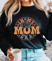 Woman wearing black sweatshirt with retro orange and teal In My Cool Mom Era print—perfect example of DTF Transfers ready to press for Mother’s Day.