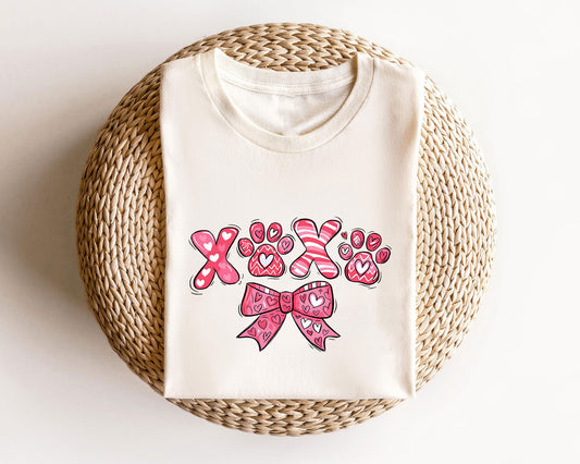 XOXO Paw Prints ready-to-press DTF transfer design with heart-filled letters, paw prints, and a pink bow.