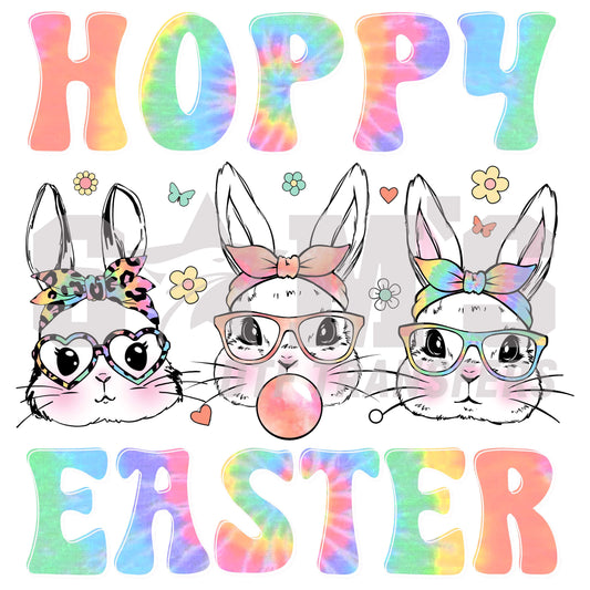 Three stylish bunny faces with glasses and bows, with the vibrant, tie-dye patterned words 'HOPPY EASTER' above and below, surrounded by spring flowers and hearts.