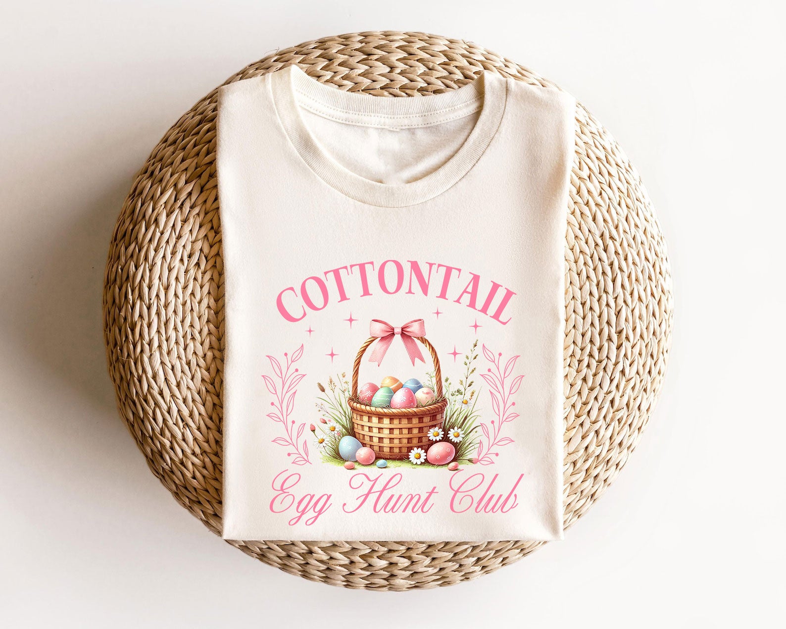 Cream t-shirt featuring a vintage Easter basket with colorful eggs, pink bow, and floral accents, perfect for Easter-themed designs.