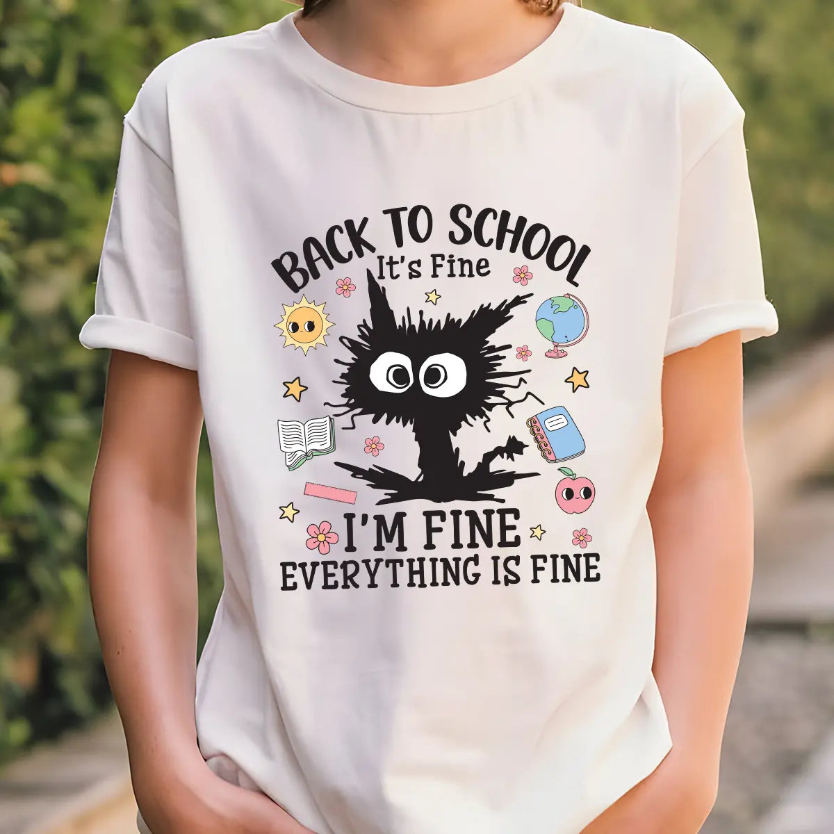 White T-shirt with black frazzled cartoon and “Back to School. It’s Fine. I’m Fine. Everything is Fine” text plus school-themed icons.