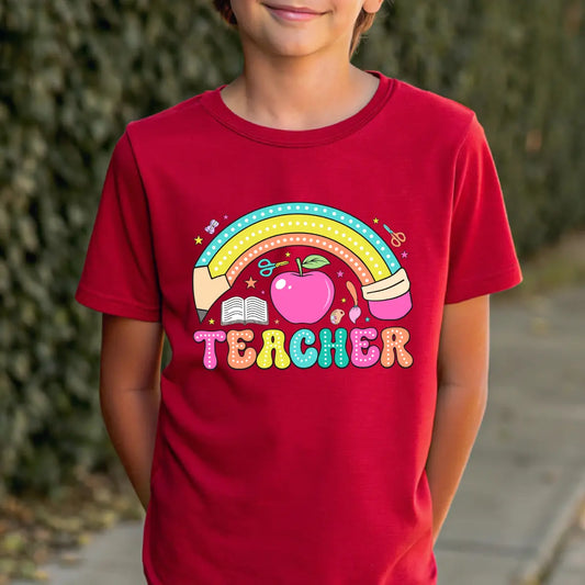 Red T-shirt with “TEACHER” DTF transfer design featuring a colorful pastel rainbow, apple, pencil, book, and scissors icons.