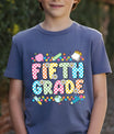 Navy-blue T-shirt with “Fifth Grade” DTF transfer design featuring colorful checkered letters, daisies, and fun school icons like globe, apple, and pencil.