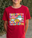 Red T-shirt with “Kindergarten” DTF transfer design featuring layered colorful text and a big multicolor patterned bow in the center.