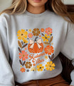 Gray sweatshirt with “Autumn Vibes” DTF transfer design featuring a pumpkin with a bow surrounded by colorful fall flowers in warm autumn tones.