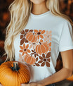 White T-shirt with modern “Pumpkin Floral Pattern” DTF transfer design featuring stylized pumpkins and flowers in warm fall colors.