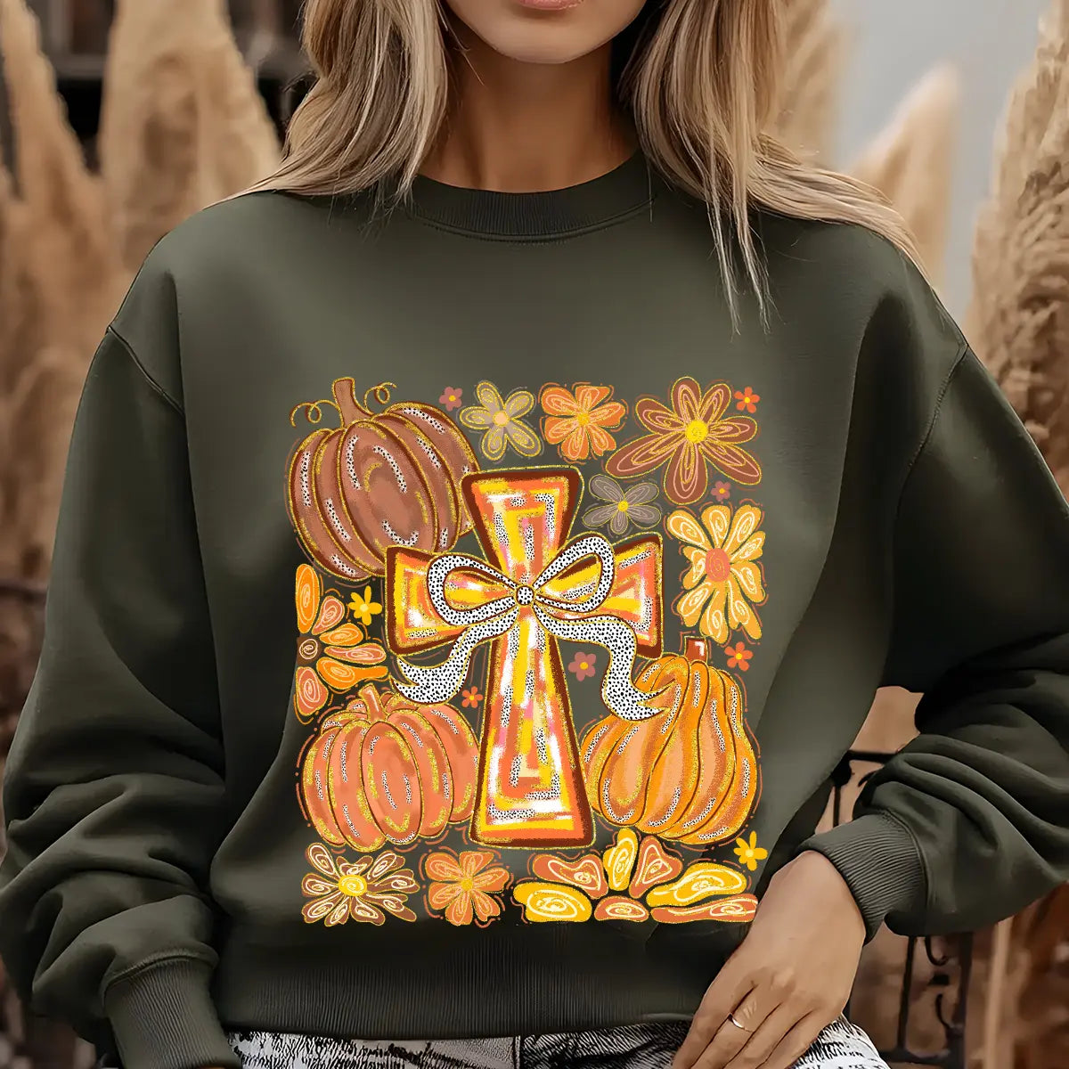 Green sweatshirt with Autumn Cross DTF transfer design featuring hand-painted cross with bow, pumpkins, and colorful fall flowers.