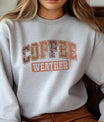 Gray sweatshirt with “Coffee Weather” DTF transfer design in large vintage collegiate lettering in warm fall colors.