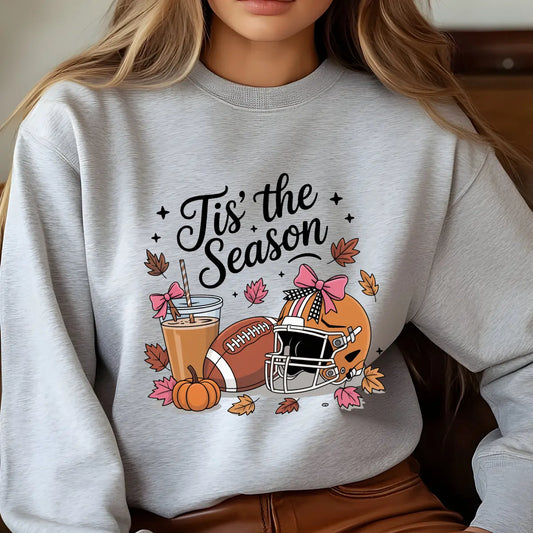 Gray sweatshirt with “Tis’ the Season” DTF transfer design featuring football, helmet with bows, iced coffee, pumpkins, and autumn leaves.