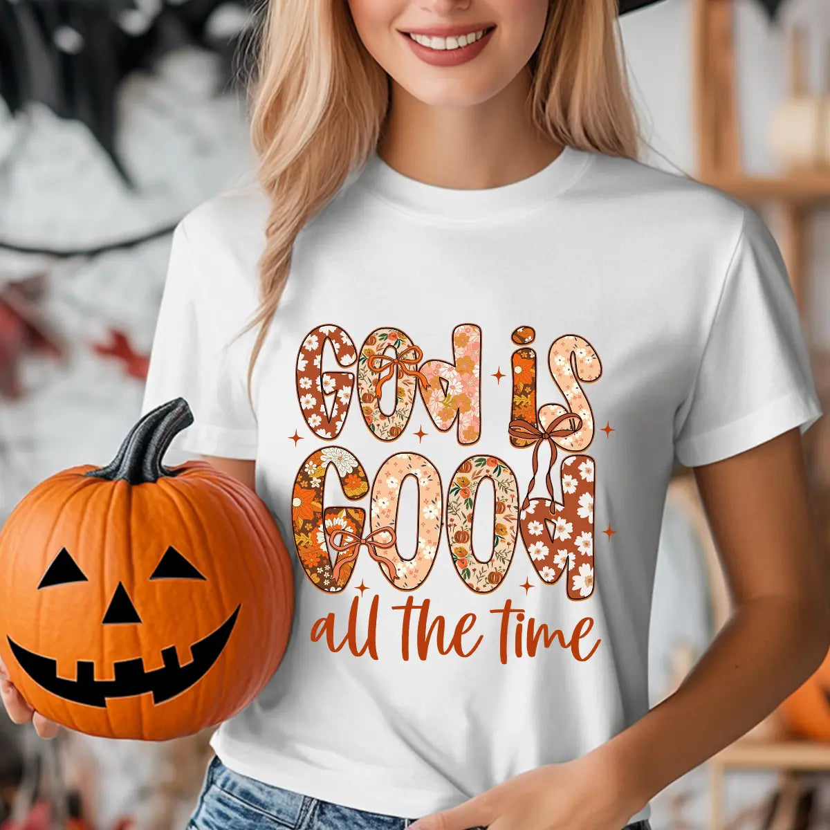 White T-shirt with “God Is Good All the Time” DTF transfer design featuring floral-patterned letters, bows, and autumn-inspired accents.