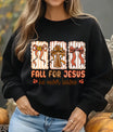 Black sweatshirt with “Fall for Jesus He Never Leaves” DTF transfer design featuring rustic cross, striped fall bows, and warm autumn colors.