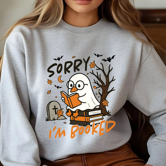Gray sweatshirt with “Sorry I’m Booked” DTF transfer design featuring a ghost duck reading on books, with fall leaves, bats, and graveyard scene.